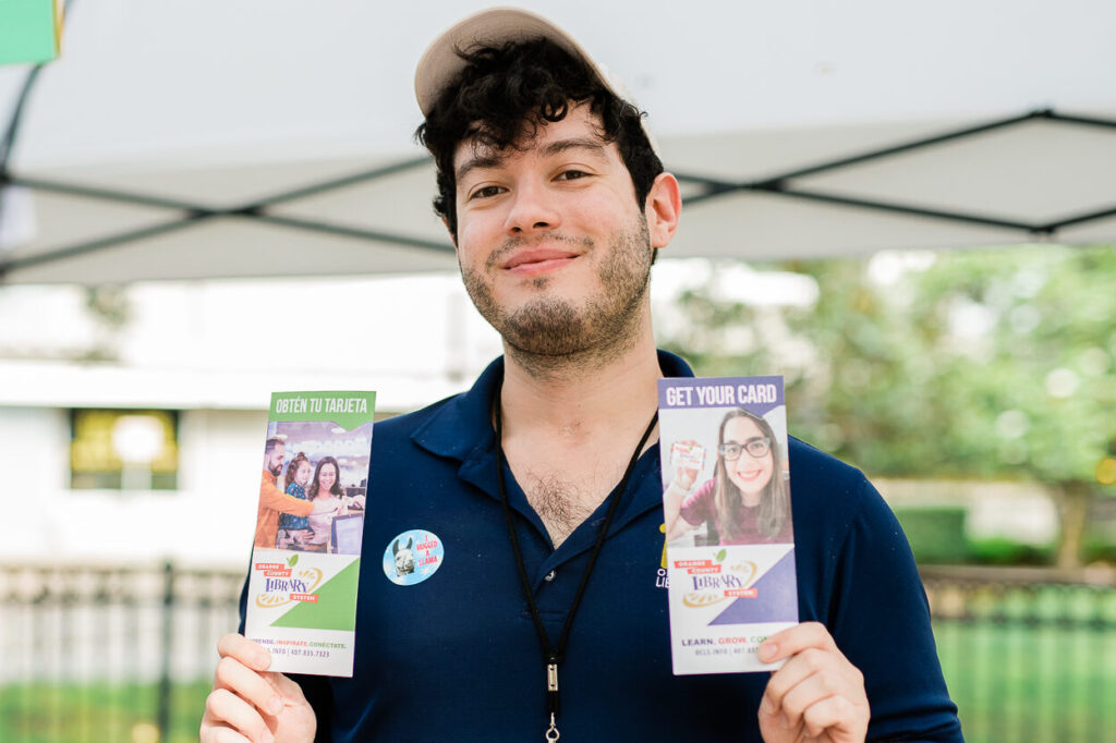 Arthur Ugalde, Branch Outreach Specialist, holding library brochures at an outdoor event