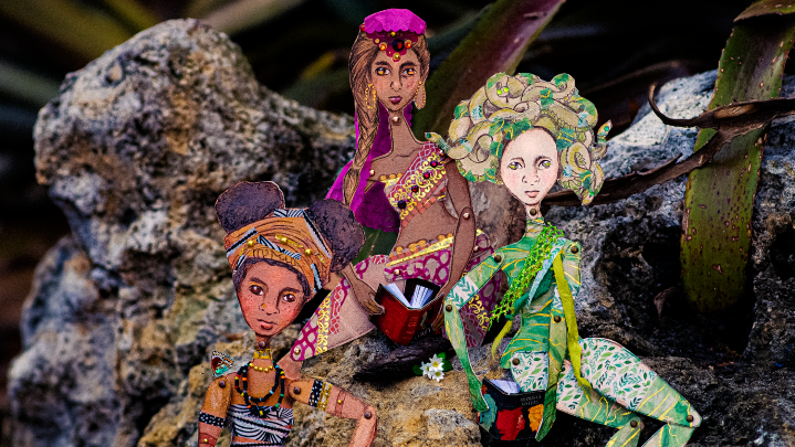Three paper dolls from mythology sitting on a rock
