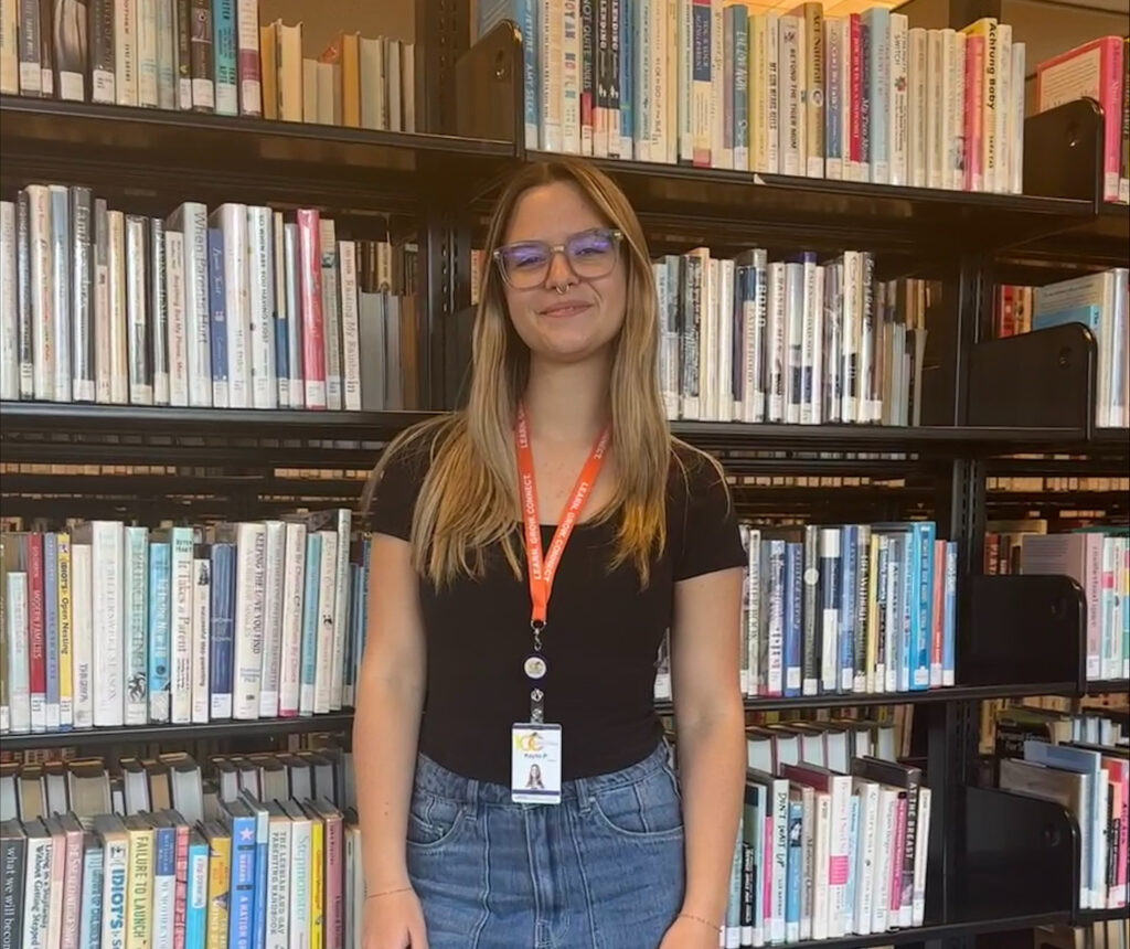 Kaylie Pasternak standing in front of a shelf full of books at Orlando Public Library